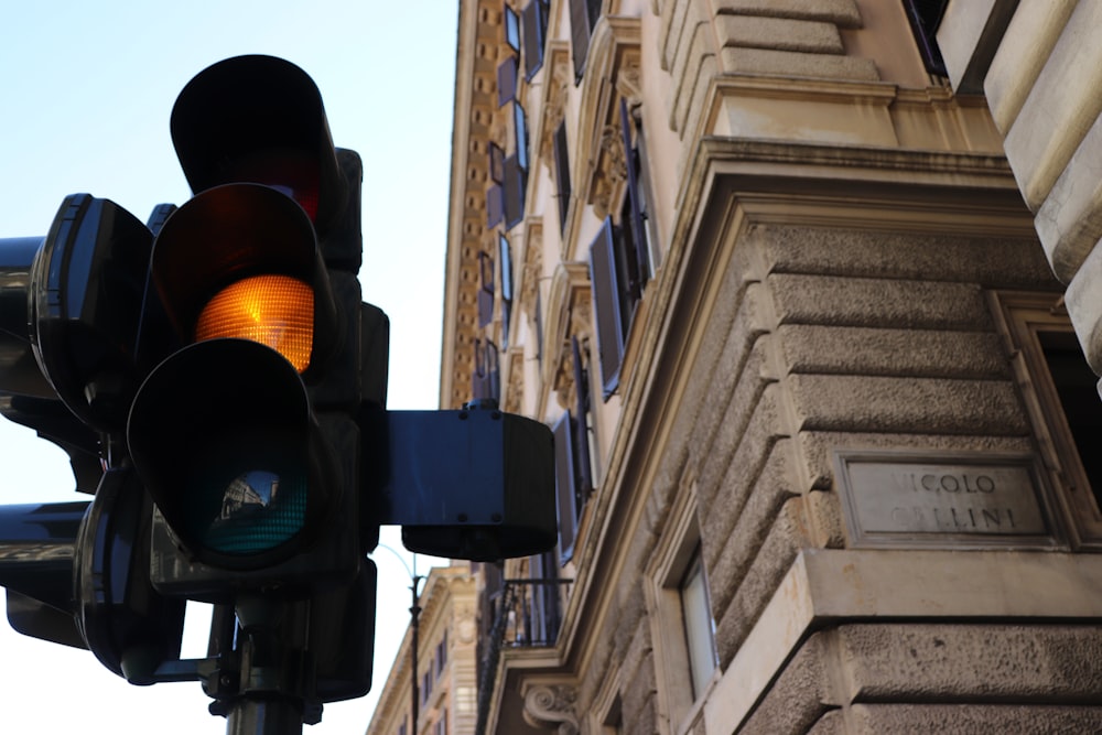 yellow light on traffic light beside brown building