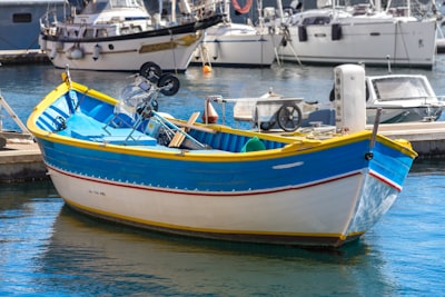 white and blue boat with no people gleaming teams background