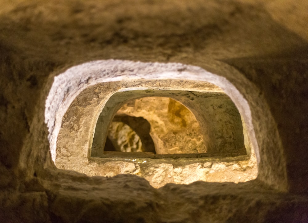 a stone tunnel with a small window in it