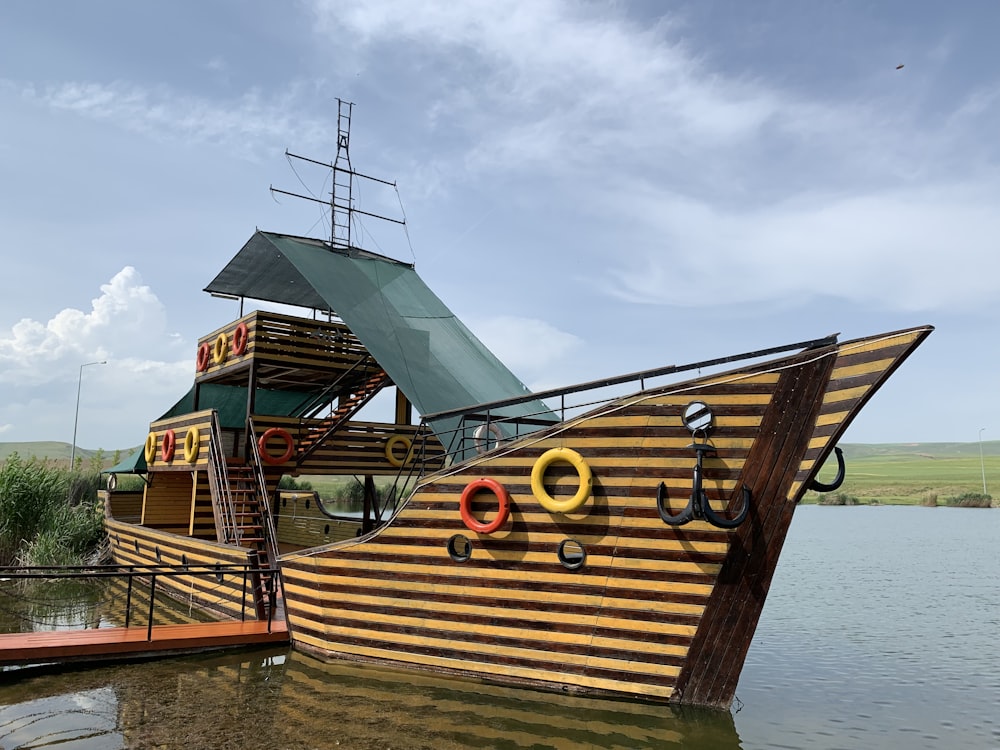 yellow and green boat near dock under blue and white skies