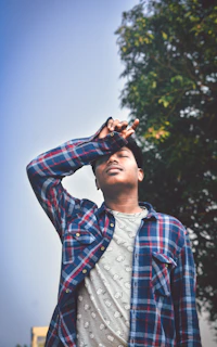 A happy customer wearing a relaxed fit muktribe shirt, standing outdoors on a sunny day.