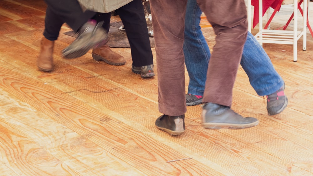 four people dancing on wooden floor