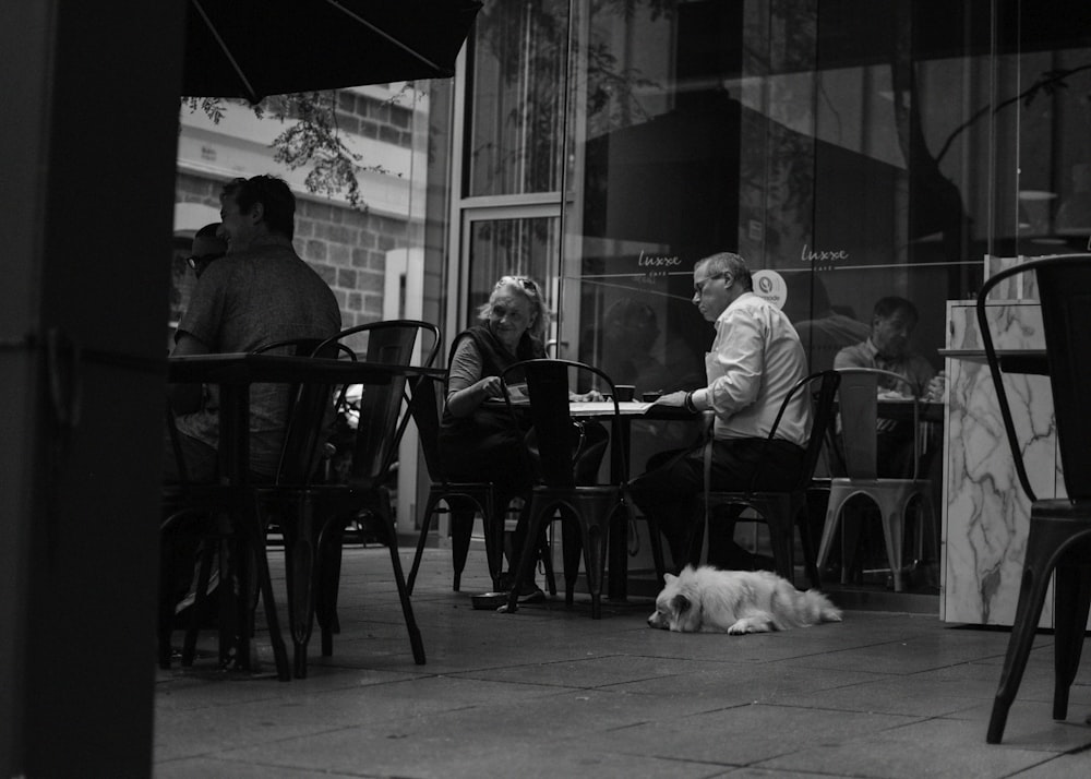 grayscale photo of people in outdoor cafe