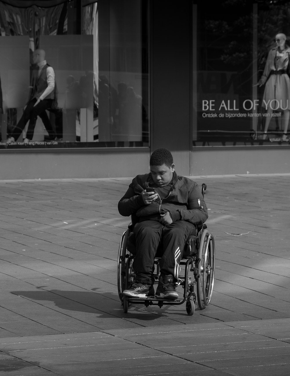 grayscale photography of man sitting on wheelchair