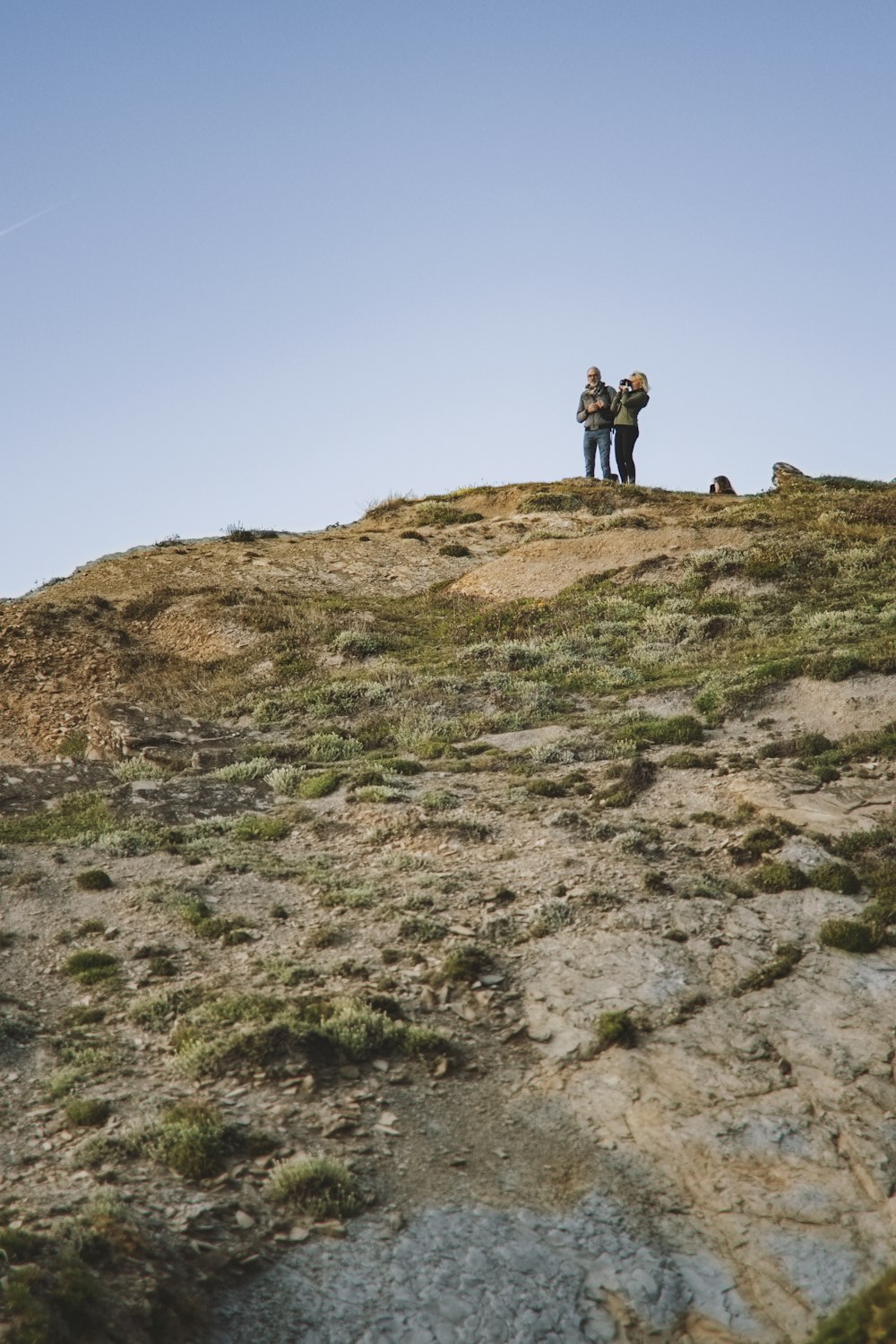two person standing on hill
