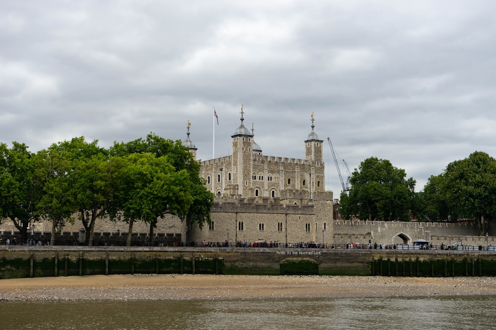 people walking near brown concrete castle under white skies