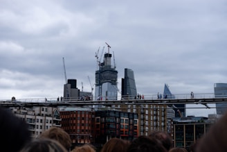 A modern urban bridge under construction with cranes and workers in safety gear.