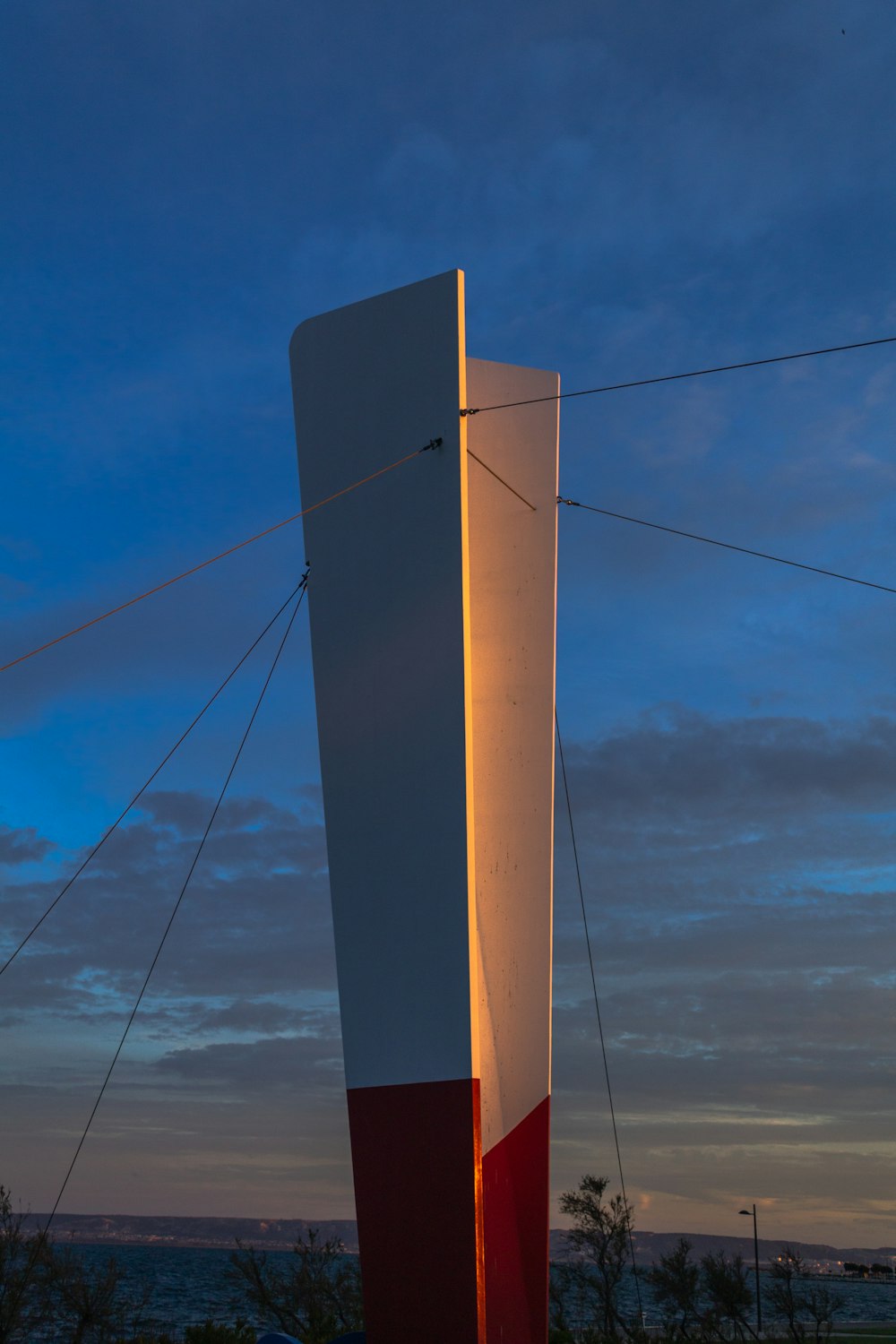 white and red concrete tower building under blue and white skies