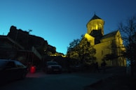 A peaceful evening shot of a modern church building illuminated against the night.