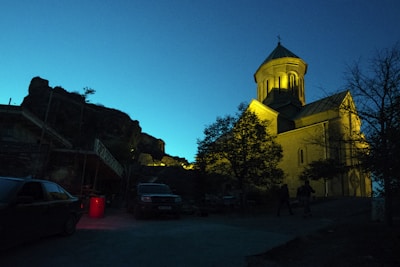 An evening shot of a local church illuminated, with neighbors walking nearby.