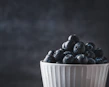 Close-up of a vibrant, hand-glazed ceramic bowl filled with fresh fruit.