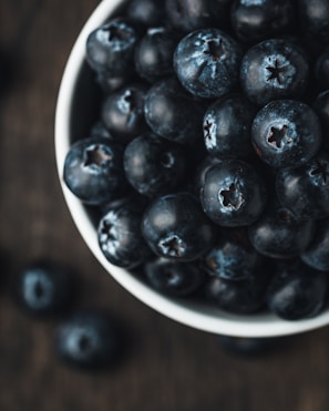 A close-up of fresh wild blueberries on a white background.