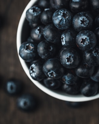 A close-up of fresh, organic blueberries on a wooden table.