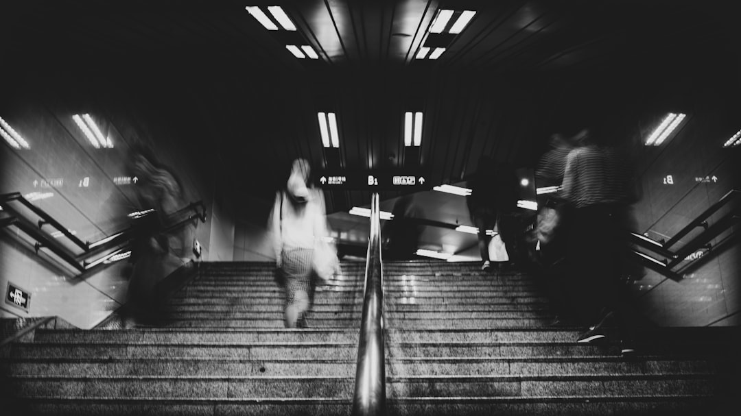 time-lapse and grayscale photo of people walking on staircase