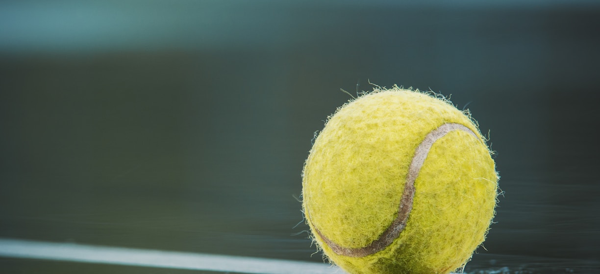 a tennis ball sitting on top of a tennis court