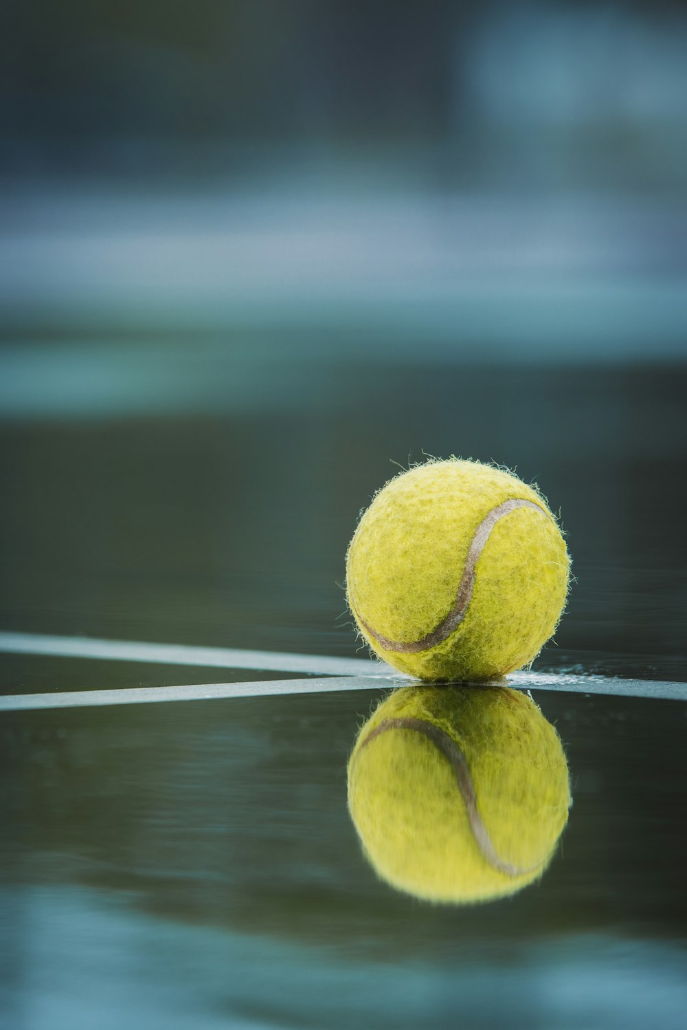 a tennis ball sitting on top of a tennis court