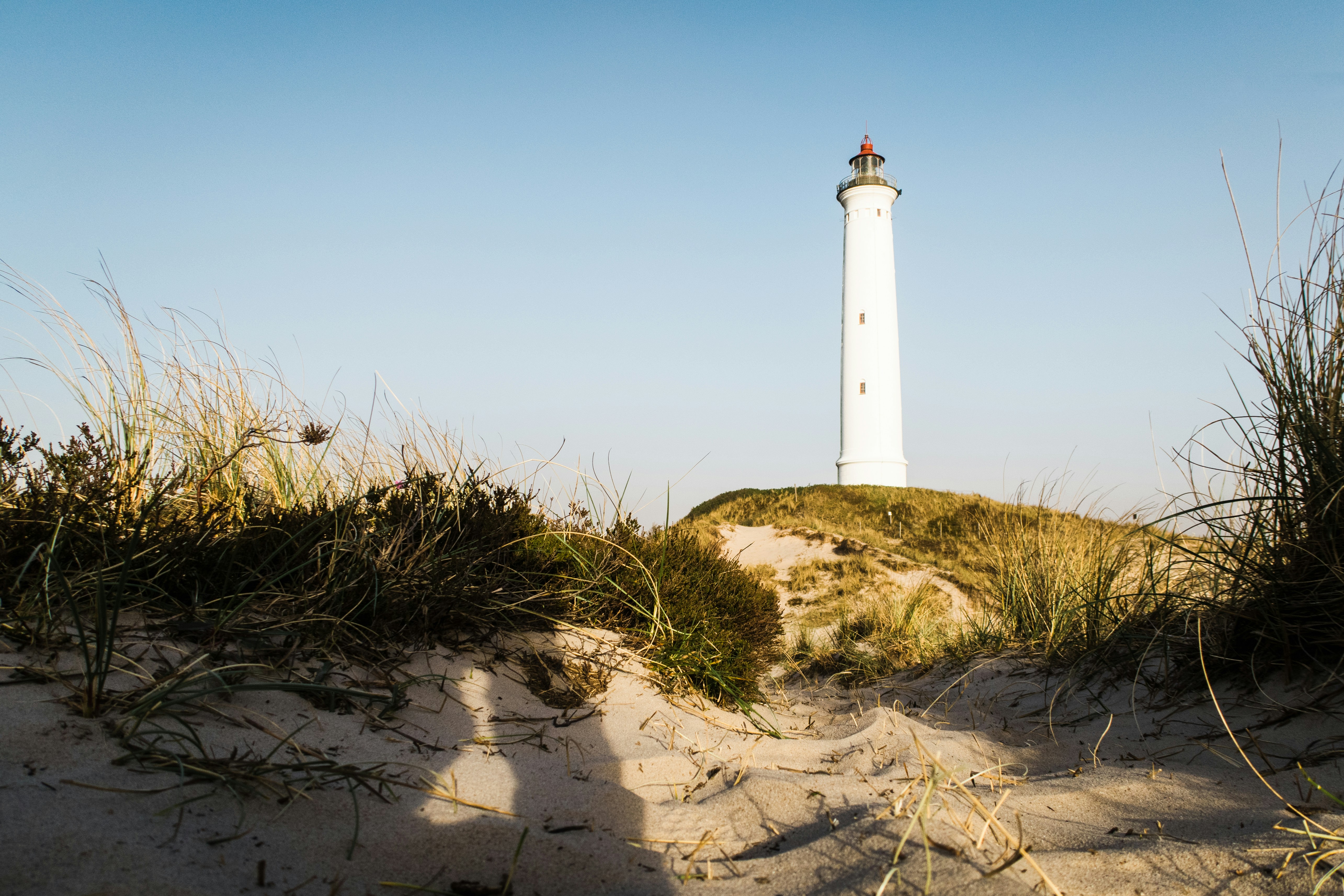Weißer Leuchtturm unter blauem Himmel