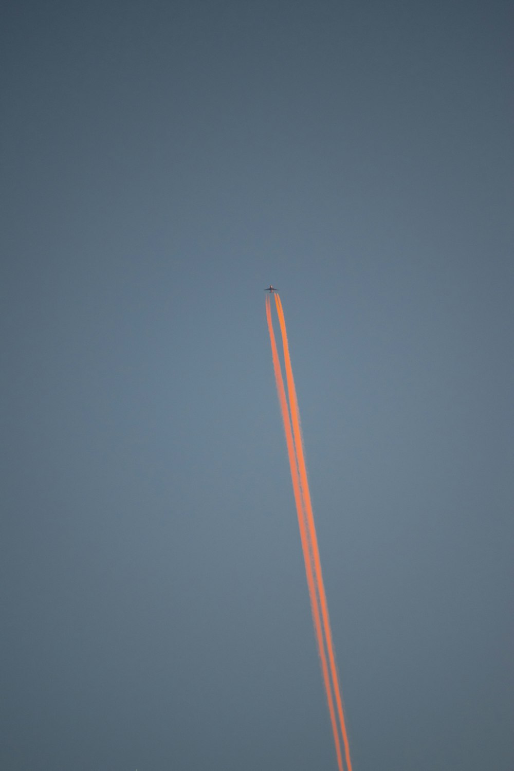 an airplane is flying in the sky with a contrail