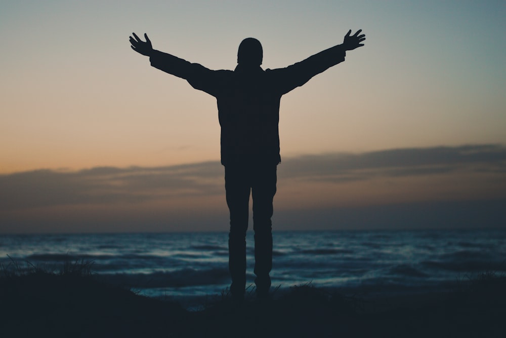 Silhouette einer Person, die dem Strand zugewandt ist