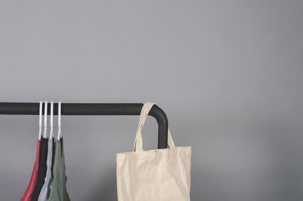 white tote bag hanged on metal rack