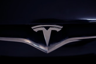 A shiny metallic emblem of a well-known car manufacturer set against a glossy black surface.