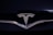 A shiny metallic emblem of a well-known car manufacturer set against a glossy black surface.