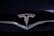 A shiny metallic emblem of a well-known car manufacturer set against a glossy black surface.