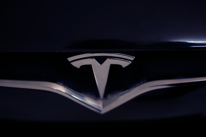 A shiny metallic emblem of a well-known car manufacturer set against a glossy black surface.