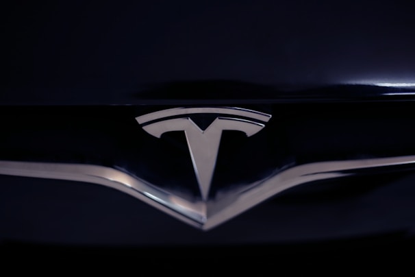 A shiny metallic emblem of a well-known car manufacturer set against a glossy black surface.