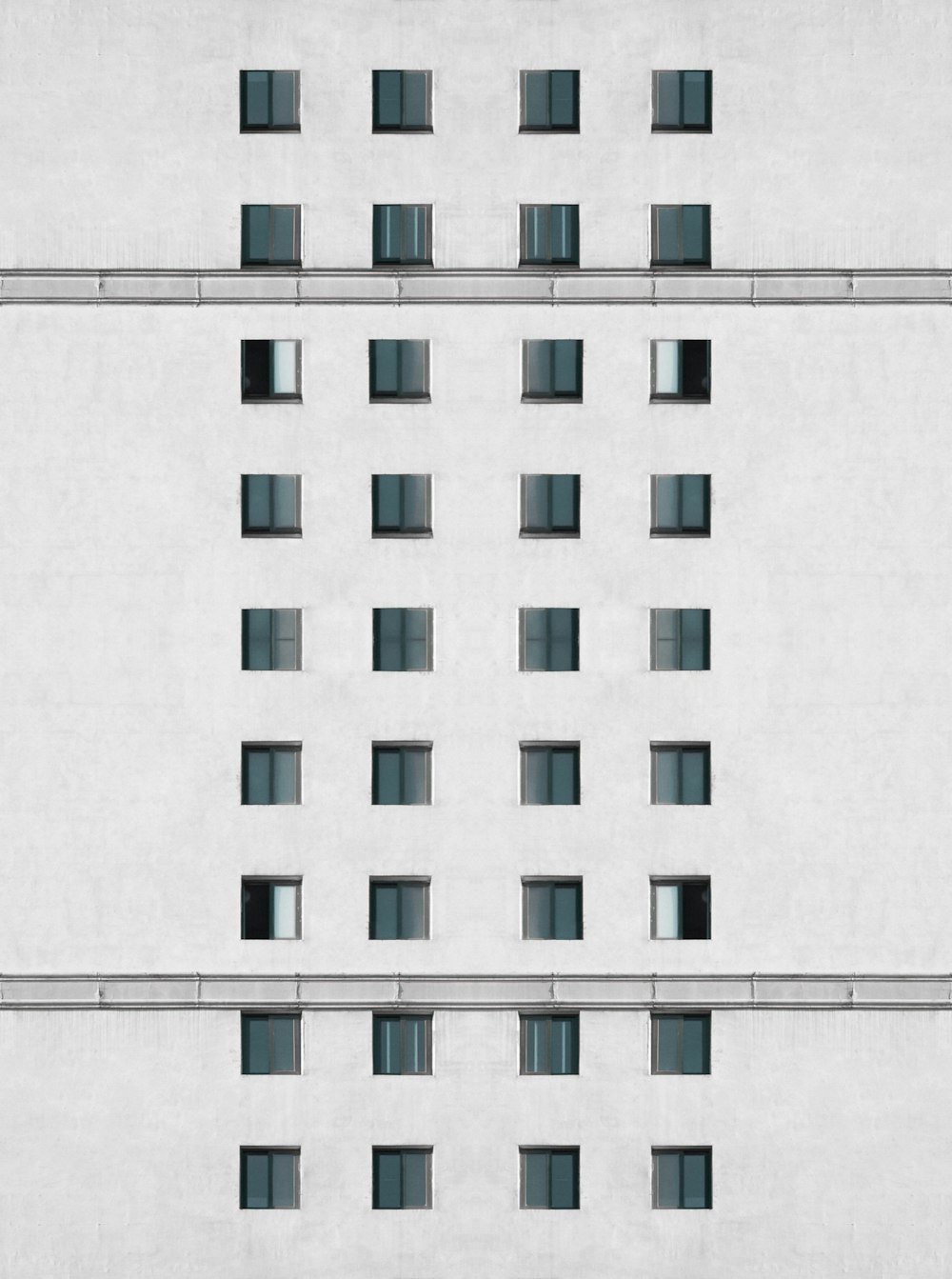 Ein weißes Gebäude mit vielen Fenstern und Gittern