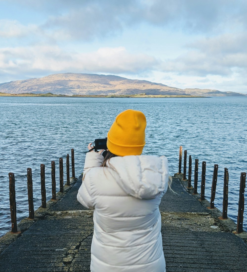 person standing on dock holding camera