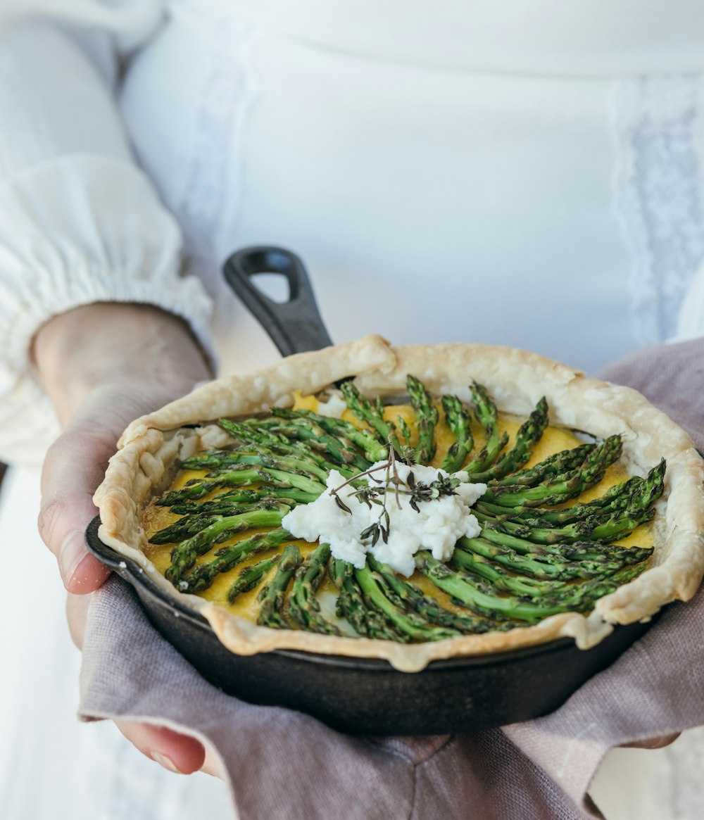 person holding cooked food in cooking pan