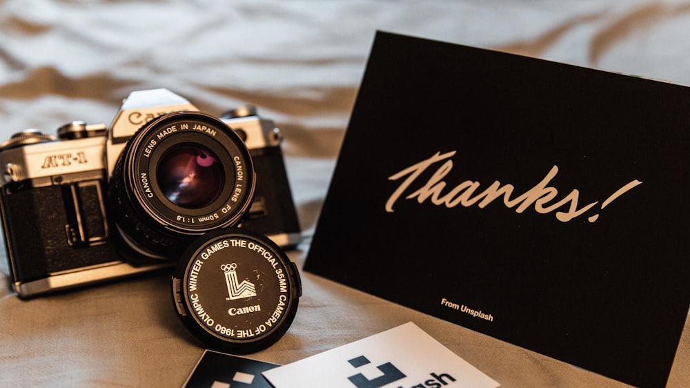 gray and black Canon camera with Thanks card