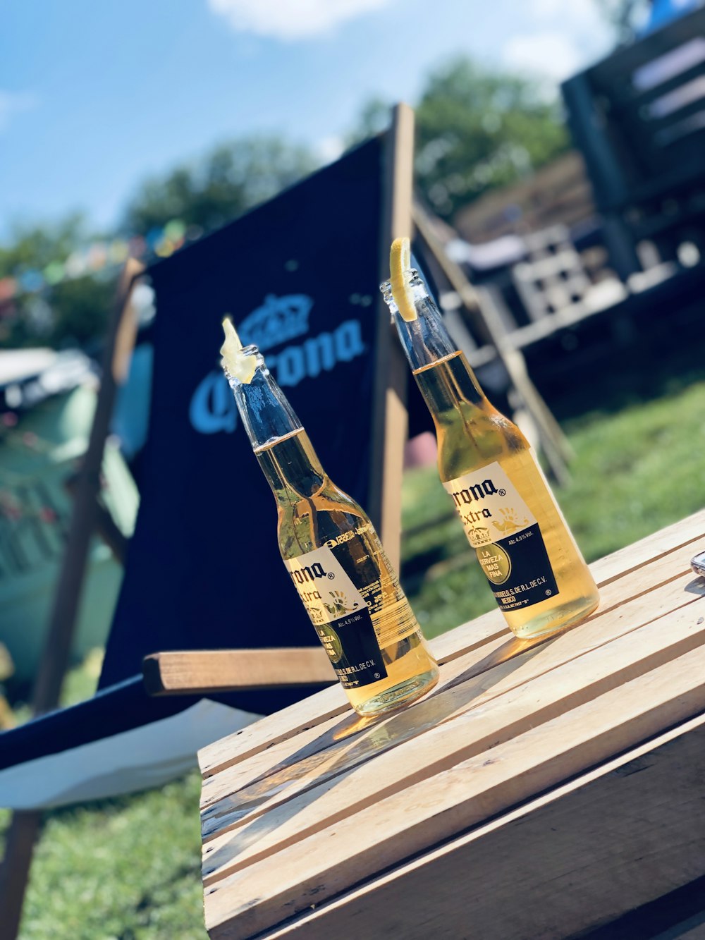 two opened Corona beer bottles on brown wooden table