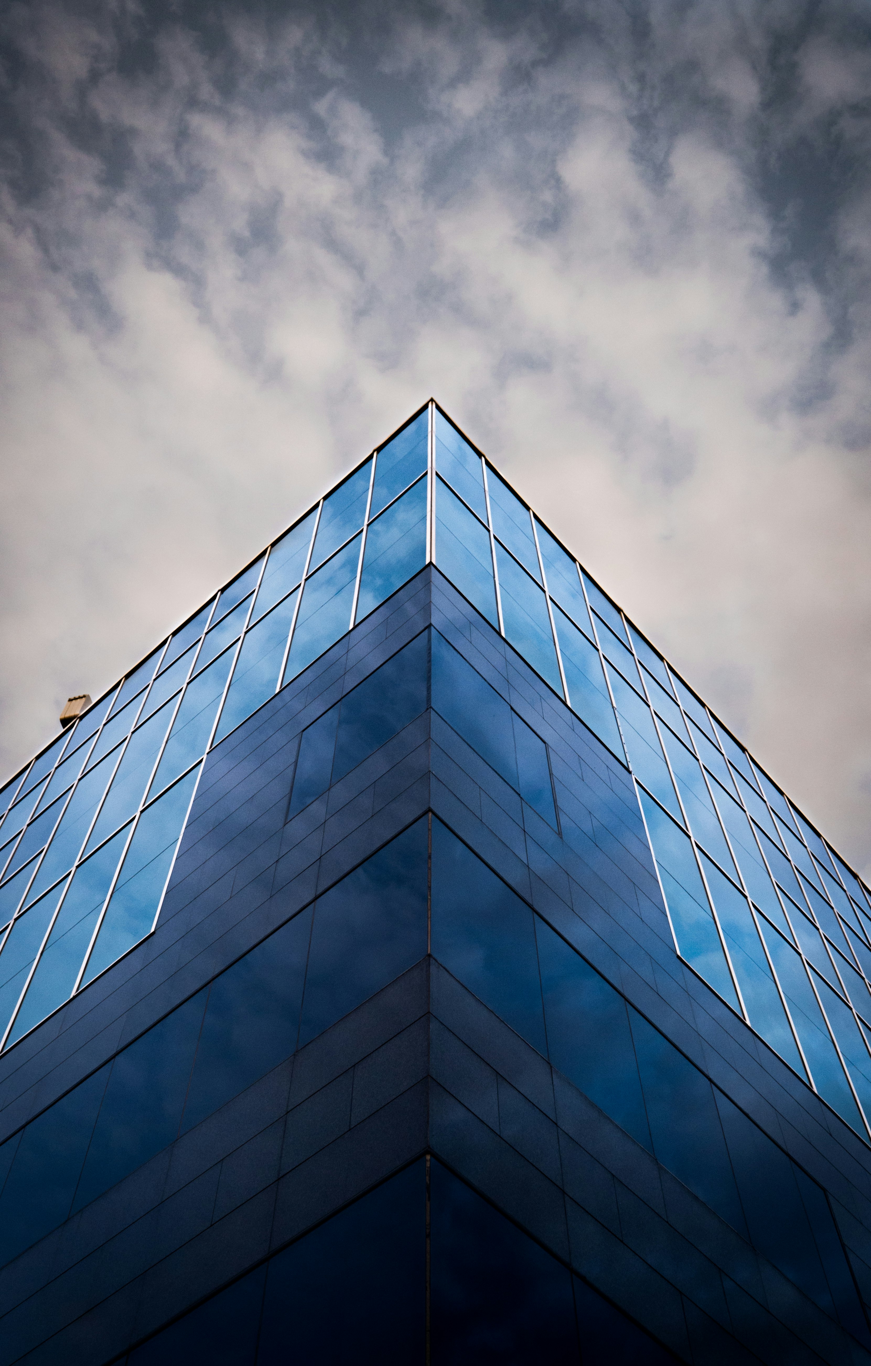 worm view photo of blue building under cloudy sky