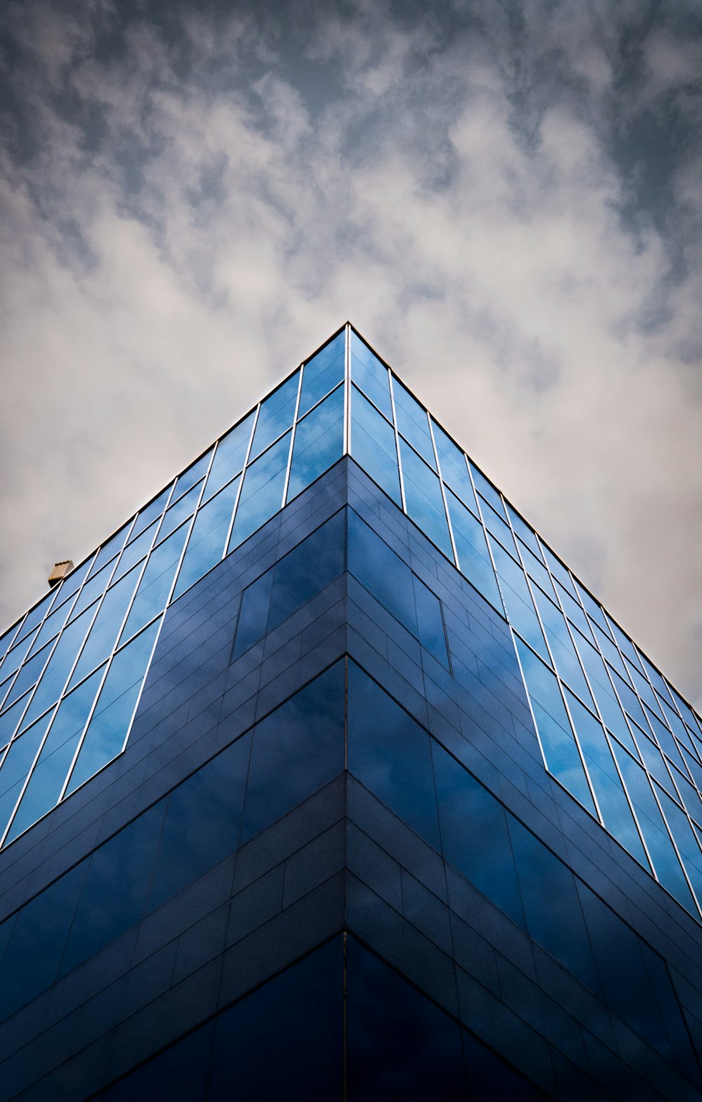 worm view photo of blue building under cloudy sky