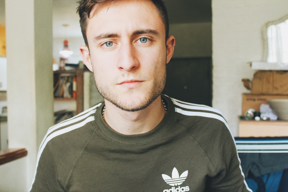 man wearing black adidas crew-neck shirt