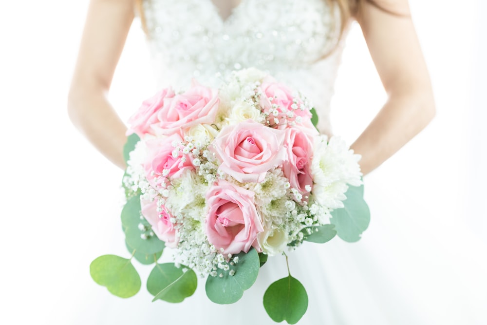 woman holding pink and white rose flower bouquet