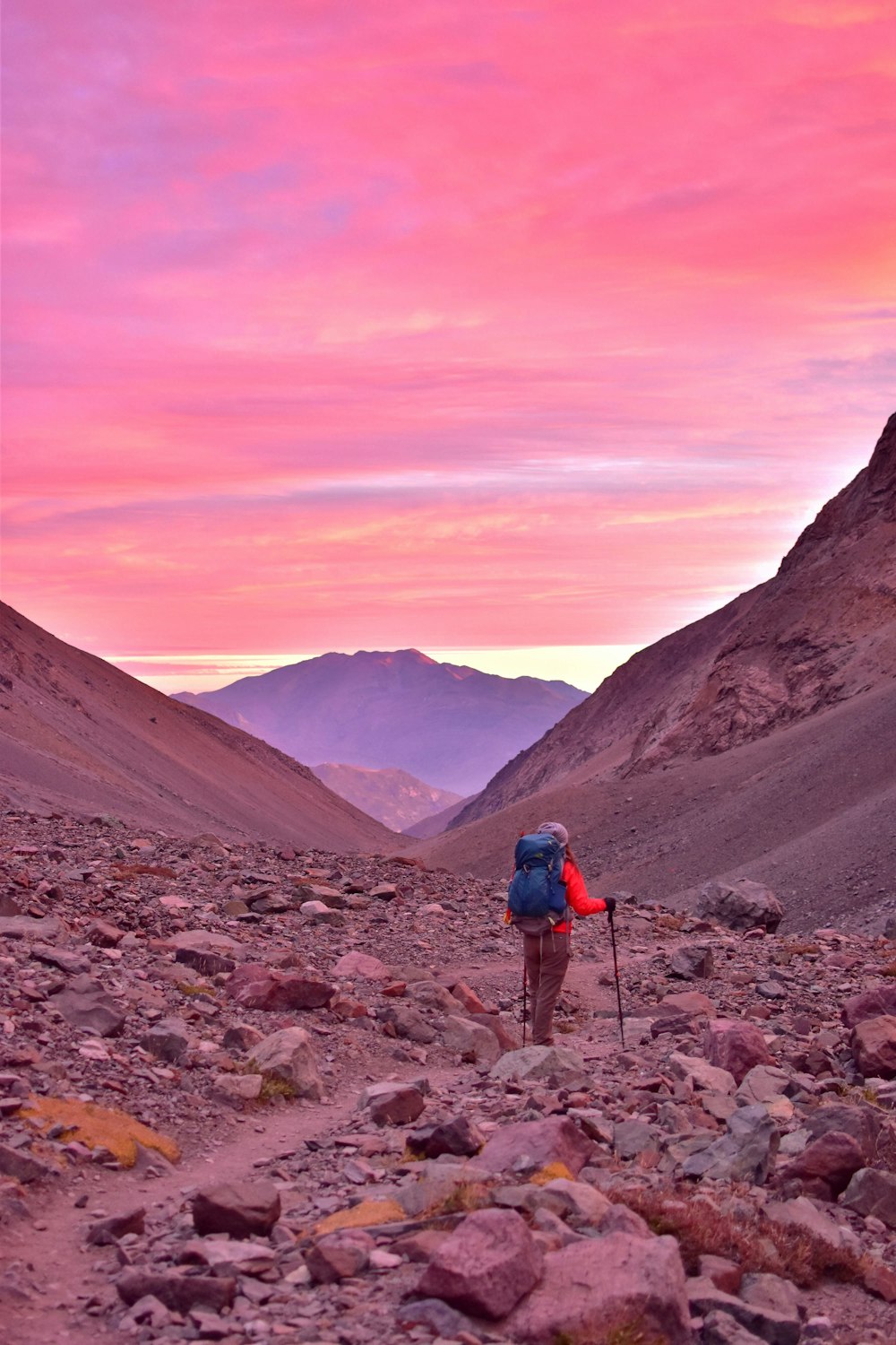 man carrying camping bag near mountain