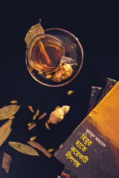 A stack of UPSC preparation books with notes and a cup of tea.