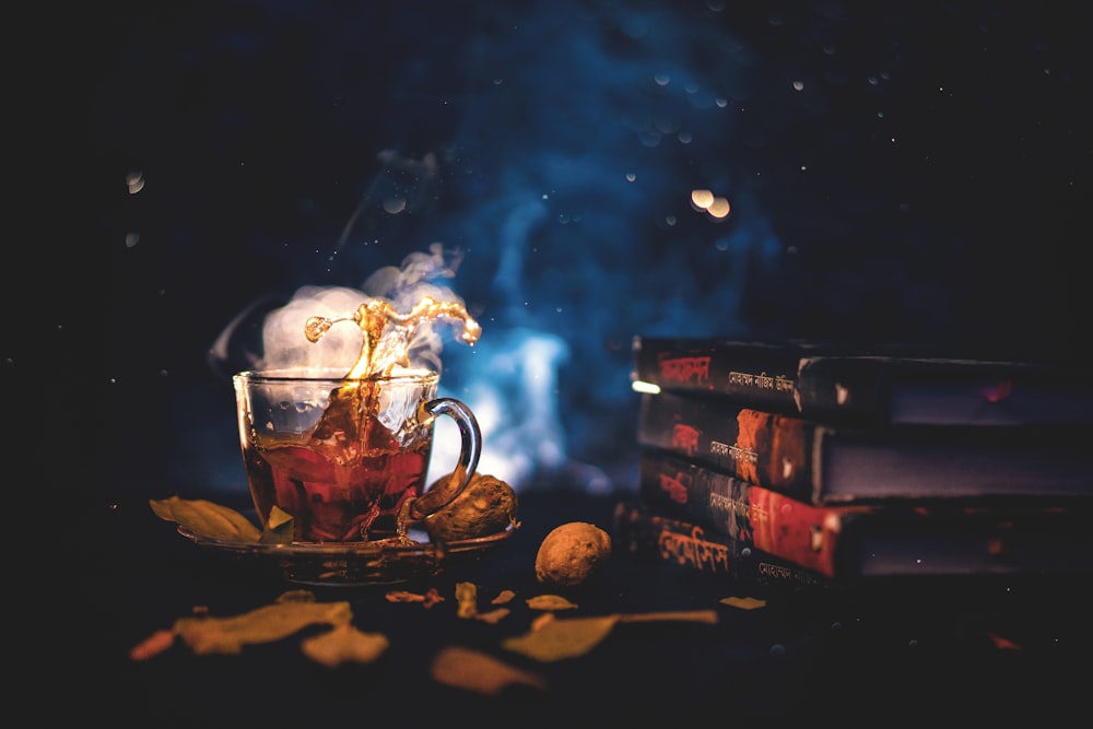 a cup of tea sitting on top of a table next to a stack of books