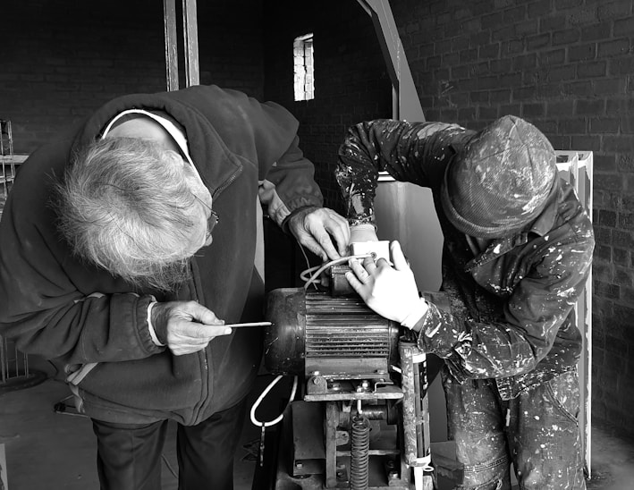 two person fixing AC motor