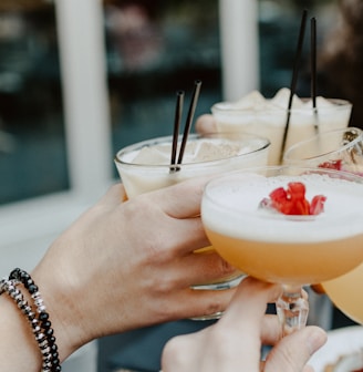 person holding filled drinking glasses