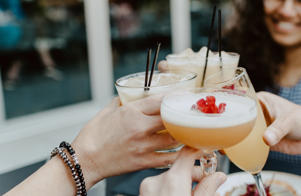 person holding filled drinking glasses