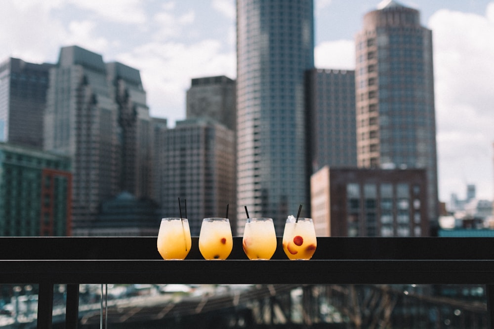 four drinking glass on black surface during daytime