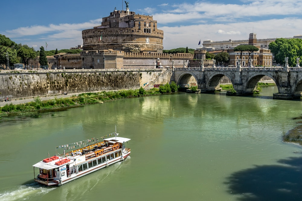 white ship on body of water near bridge during daytime