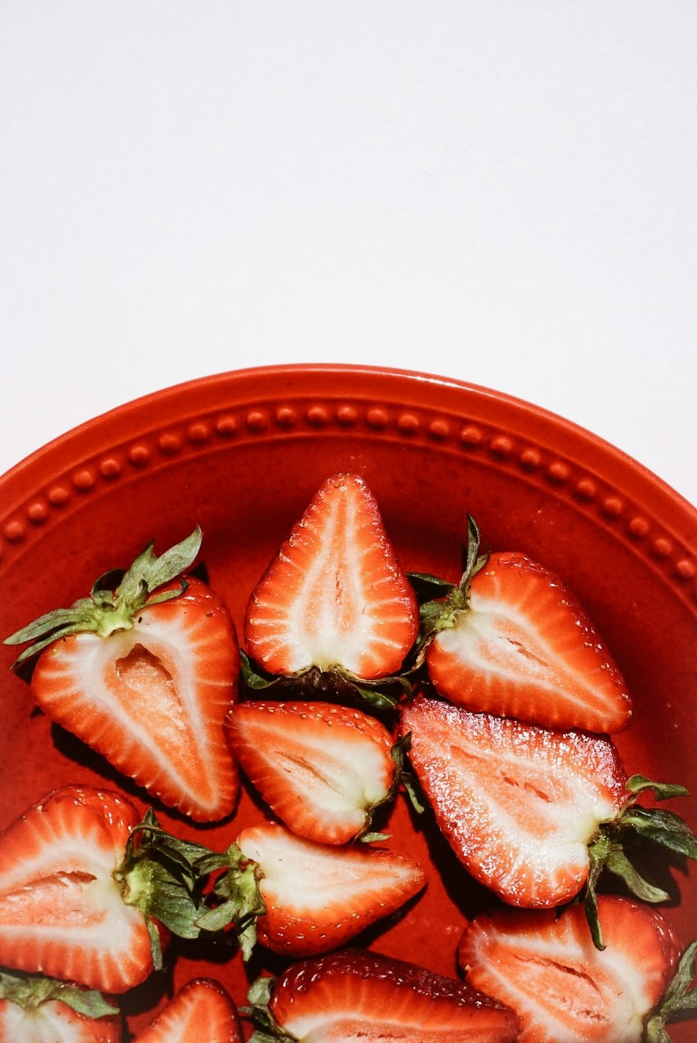 sliced strawberries on bowl