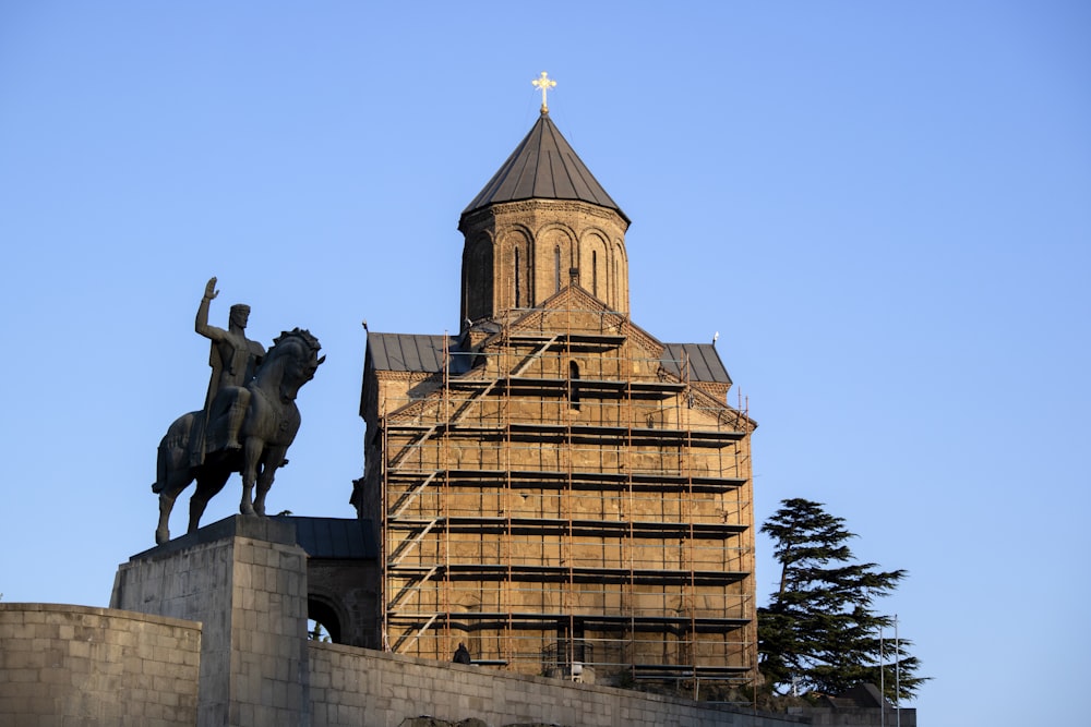 man riding horse statue near building