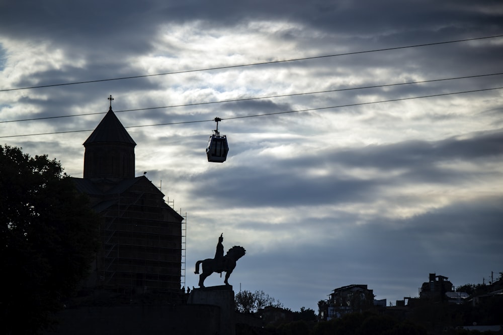 silhouette of person riding horse statue during daytime