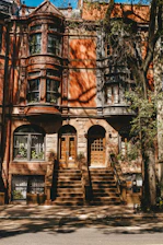 Exterior view of the classic brownstone building at 939 Putnam Avenue with warm sunlight highlighting its architectural details.